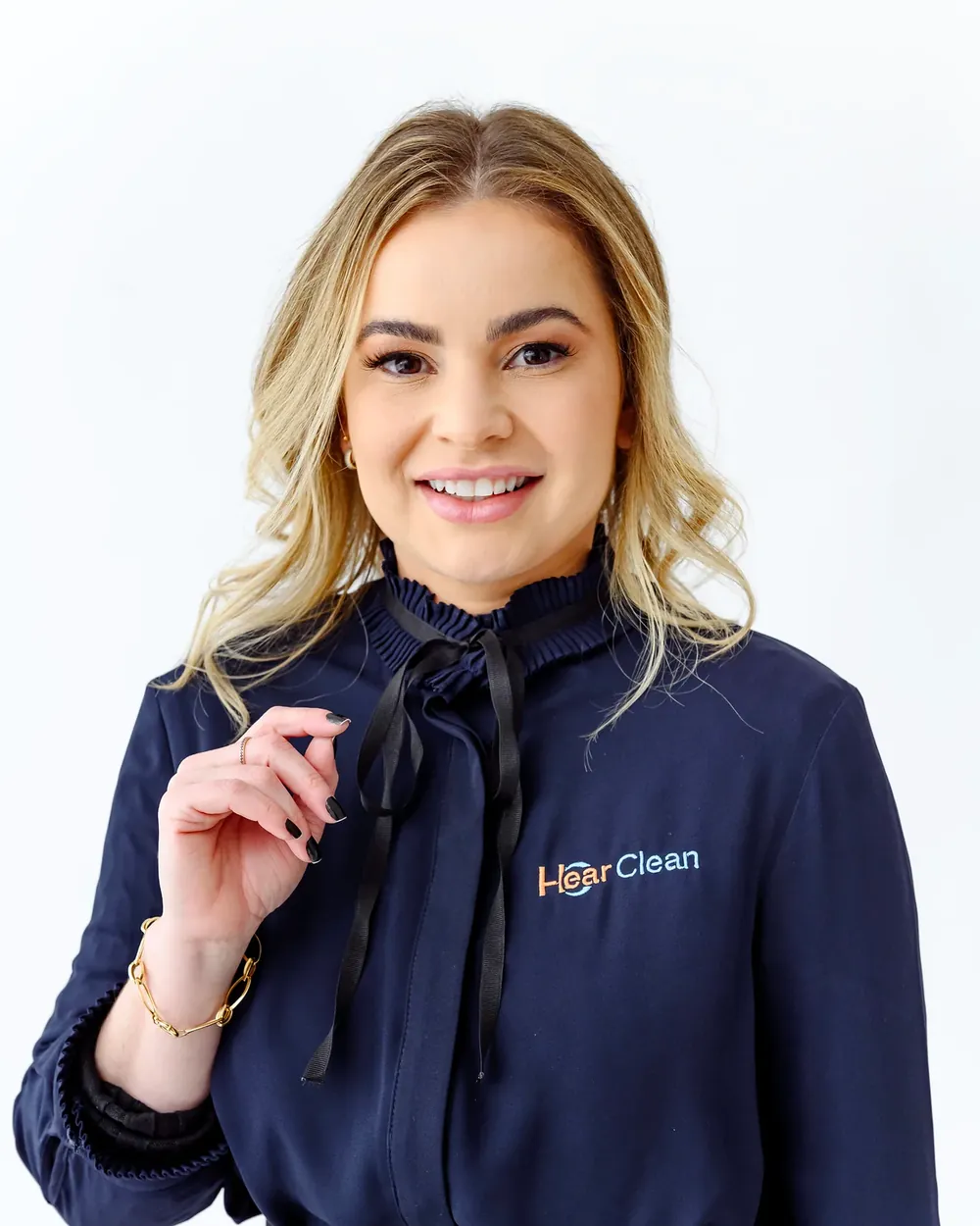 Fonoaudióloga da Hear Clean sorrindo, com a camisa da clínica